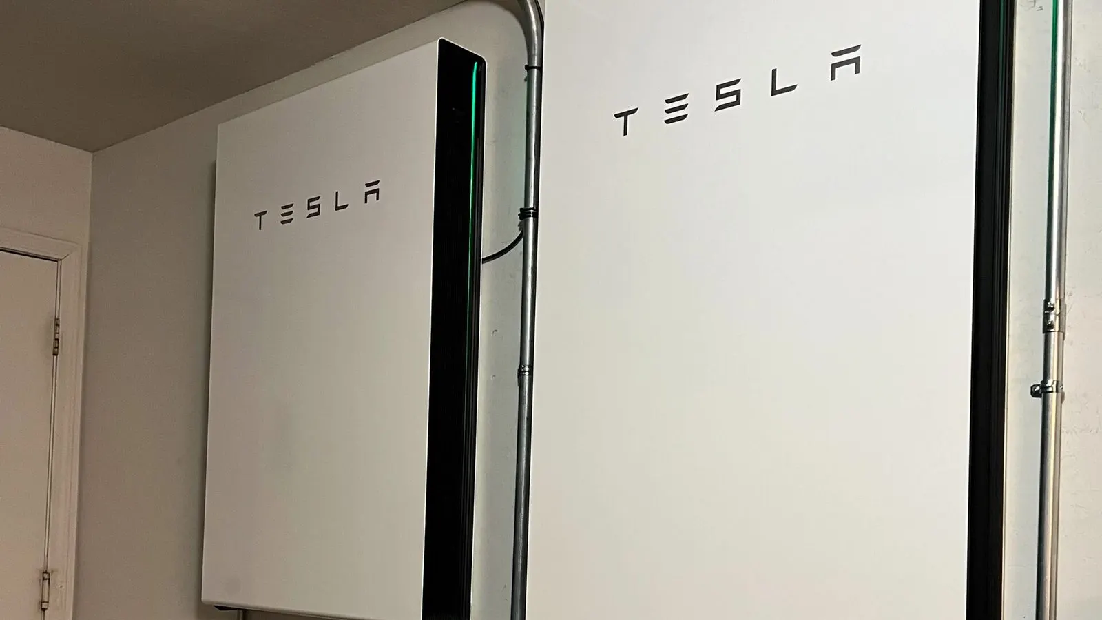 Twee thuisbatterijen aan de muur in een woning, met een scheidingsschakelaar eronder